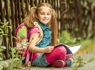 schoolgirl reading a book  on the street